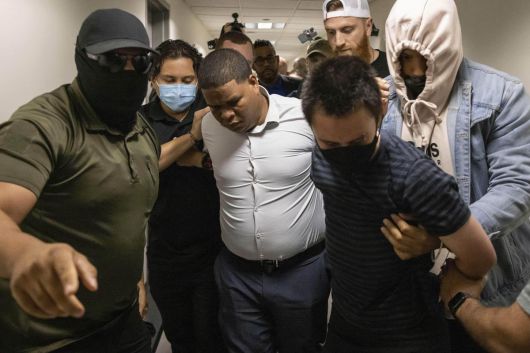 6일 뉴욕 이민 법원에서 흰 셔츠를 입은 도미니카공화국 출신 이민자와 줄무늬 티셔츠를 입은 이민 활동가가 사복을 입은 이민 당국자들에게 연행되고 있다. 뉴욕=AP 뉴시스