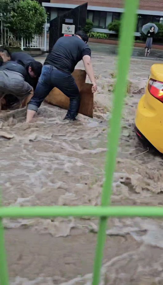 17일 광주 동구 소태동에서 최승일 씨와 직원들이 폭우 속 익사위기에 놓은 70대 노인이 숨을 쉴 수 있도록 합판으로 쏟아져 내려오는 물을 막고 있다. 옆에는 직원들이 떠밀려온 승용차를 막고 있다. 최승일 씨 제공