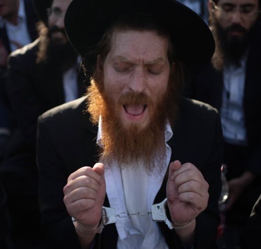 군 복무 반대 시위 벌이는 하레디 지난해 6월 이스라엘 예루살렘에서 초정통파 유대교도인 하레디 남성이 수갑을 찬 채 군복무 반대 시위를 벌이고 있다. 예루살렘=AP 뉴시스