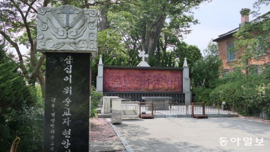 공세리성당 한쪽에 있는 병인박해 등 순교자 32명을 기리는 현양비와 현양탑, 그리고 벽면 조각.