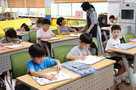 초등학교에서 19일 1~2학년 학생들이 도서관에서 방과후 수업으로 미술수업을 하고 있다.