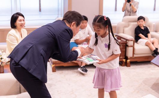 이재명 대통령이 4일 서울 용산 대통령실 청사에서 어린이 초청 행사에 참석한 어린이들에게 책을 선물하고 있다. 사진=대통령실 제공