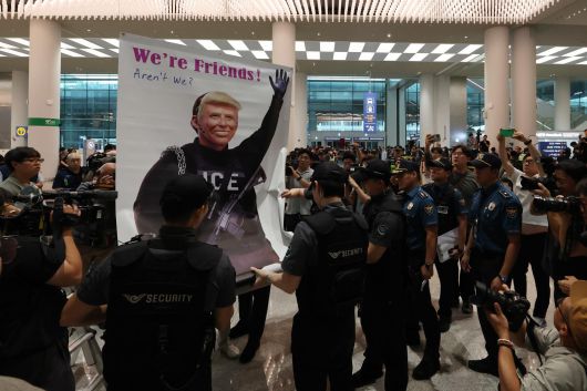 미국 이민당국에 의해 조지아주에 구금됐던 한국인 근로자들이 귀국한 12일 인천국제공항 제2여객터미널 입국장에서 도널드 트럼프 미국대통령 얼굴 배너를 든 시민단체가 시위하고 있다. 2025.9.12/사진공동취재단