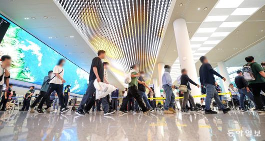 미국 이민당국에 의해 체포·구금됐다 풀려난 한국인 근로자들이 12일 인천 국제공항 제2터미널 입국장으로 빠져나오고 있다.  박형기 기자 oneshot@donga.com