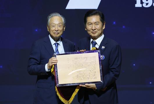 정청래 더불어민주당 대표가 19일 서울 여의도 국회 의원회관에서 열린 더불어민주당 창당 70주년 기념식에서 권노갑 김대중재단 이사장에게 김대중 전 대통령의 입당성명서를 전달받고 있다. 2025.09.19 [서울=뉴시스]