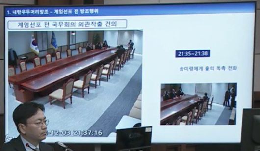 서울중앙지법 형사합의33부(부장판사 이진관) 심리로 열린 한덕수 전 국무총리 2차 공판에서 특검이 제시한 12·3 비상계엄 당일 대통령실 폐쇄회로(CC)TV 영상 화면에 한덕수 전 국무총리가 휴대전화로 누군가와 통화하는 모습이 담겨있다. 특검 측은 “국무회의 의사정족수가 채워지지 않자 송미령 농림축산식품부 장관에게 직접 전화해 대통령실로 빨리 오라고 독촉하는 모습”이라고 했다. 법원 공판 중계 화면 캡처