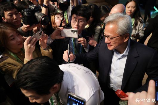 31일 황 CEO가 기자회견을 마친 뒤 한 취재진의 등에 사인을 하고 있다. 경주=박형기 기자 oneshot@donga.com