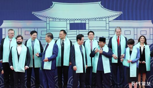 이재명 대통령이 1일 경북 경주화백컨벤션센터에서 APEC 정상회의에 참석한 각국 정상들과 전통한복 목도리를 하고 단체 기념촬영을 준비하고 있다. 목도리에는 APEC 정상회의 엠블럼과 한글 자음 모음이 금박으로 새겨져 있다. 경주=송은석 기자 silverstone@donga.com