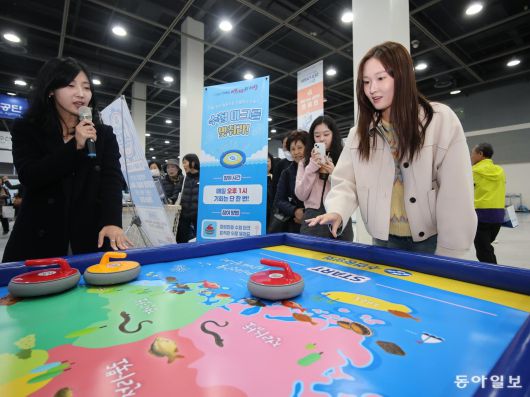 7일 오전 서울 양재동 aT센터에서 열린 ‘2025 씨팜쇼’ 내 수협 부스에서 시민들이 컬링 이벤트에 참여하고 있다.  송은석 기자 silverstone@donga.com