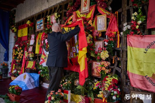 스페인 독재자 프란시스코 프랑코의 사망 50주년인 11월 20일, 한 남성이 마드리드 교외의 그의 묘소 앞에 헌법 제정 이전 스페인 국기를 걸고 있다. AP 뉴시스