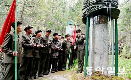 양강도로 답사 행군을 온 남성들이 구호나무 앞에서 여성 강사 설명을 듣고 있다. 동아일보 DB