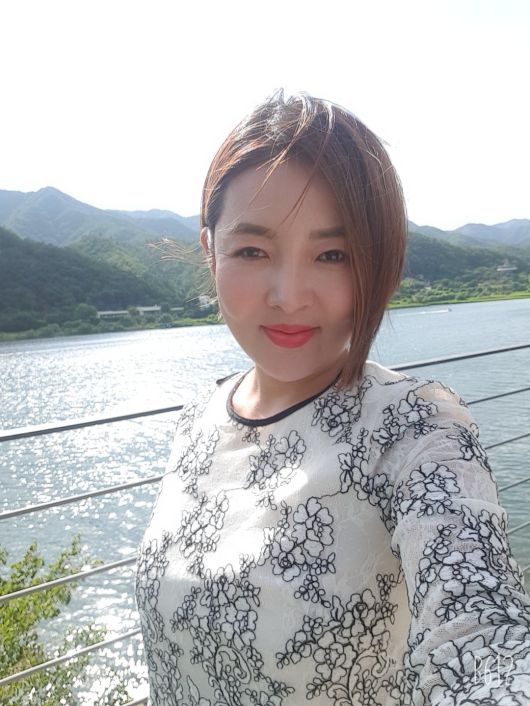 2016년 중고차 판매왕 워크샵에 참가한 이유미 씨가 남한강을 배경으로  셀피를 찍고 있다.