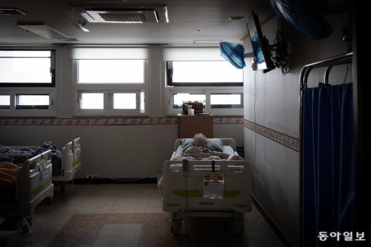 지난달 19일 불이 꺼진 요양원 방 안에 한 치매노인이 누워 잠을 청하고 있다.
