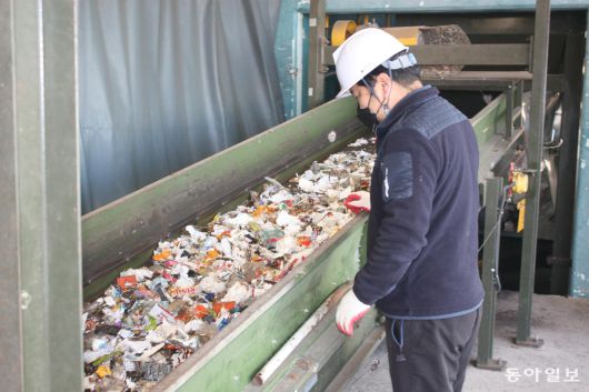 강원 고성군 죽왕면 생활폐기물 전처리 선별시스템 처리장에서 관계자가 선별기를 거쳐 분류된 폐비닐이 컨베이어벨트를 따라 이동하는 모습을 지켜보고 있다. 고성=이인모 기자 imlee@donga.com
