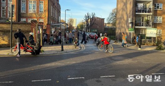 5일 오전(현지 시간) 영국 런던 해크니구 게이허스트 커뮤니티 초등학교 앞 도로가 등교하는 학생들로 붐빈다. 이 도로는 평일 등하교 시간에 차량을 전면 차단하는 ‘스쿨 스트리트’ 프로그램이 적용된다. 런던=오승준 기자 ohmygod@donga.com