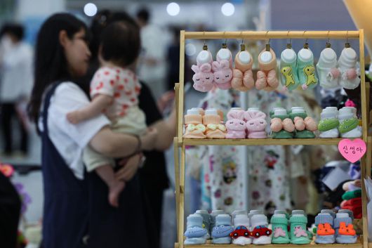 서울 강서구 코엑스 마곡에서 열린 한 베이비페어 행사에서 아이를 안은 여성이 육아용품을 둘러보고 있다. 뉴시스