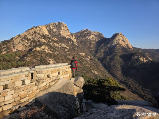 노을이 비치는 원효봉의 북한산성 성벽.