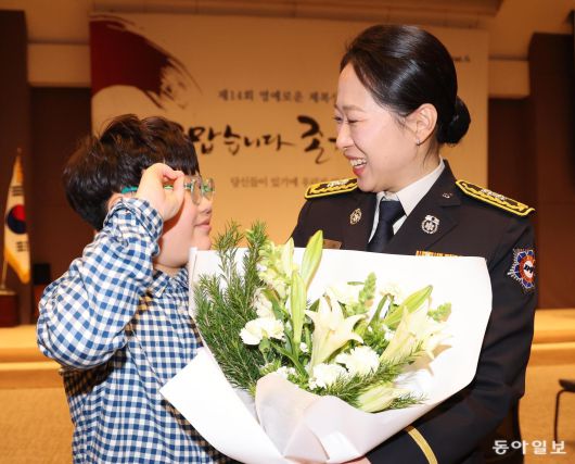 제복상을 수상한 이주희 소방경이 아들 장재희 군으로부터 축하를 받고 있다. 이 소방경은 순직 소방관 추모 문화제인 ‘119메모리얼데이’를 기획하는 등 순직 소방 공무원 예우 문화를 정착시키는 데 앞장섰다. 이한결 기자 always@donga.com