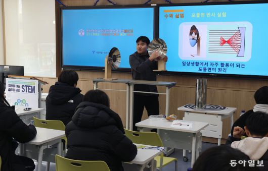 14일 서울 동작구 영등포중에 있는 ‘수학과학융합교육센터’의 수업에서 이성훈 개봉중 교사가 포물면 반사 실험기를 들고 학생들에게 포물선의 원리와 특성을 설명하고 있다. 학생들은 포물면 반사 실험기를 직접 보며 포물선이 손전등 등에 활용되는 것을 배웠다. 김재명 기자 base@donga.com