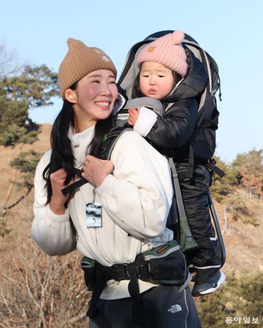 베이비하이킹클럽 운영진 김지영 씨가 딸을 업고 서울 광진구 아차산 해맞이코스 1보루에 올라 활짝 웃고 있다. 신원건 기자 laputa@donga.com