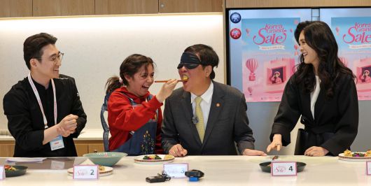 최휘영 문화체육관광부 장관이 22일 서울 영등포구 더현대 서울 문화센터에서 진행되고 있는 코리아그랜드세일의 체험행사 ‘케이-소스 활용 한식 쿠킹클래스’에서 외국인 관광객이 만든 쌈밥을 맛보고 있다.(문체부 제공)