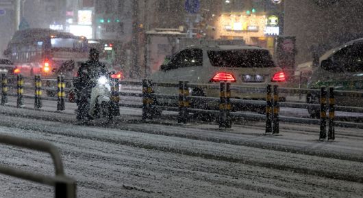 서울에 눈이 내린 23일 오후 서울 중구 인근에 오토바이가 서행하고 있다. 2026.01.23 뉴시스
