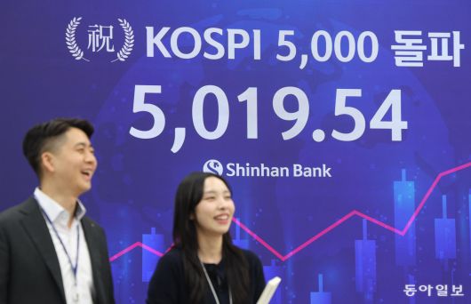 22일 코스피 사상 최고가인 5019.54가 송출되는 서울 중구 신한은행 본사 로비 전광판 앞에서 직원들이 환하게 웃고 있다. 신원건 기자 laputa@donga.com