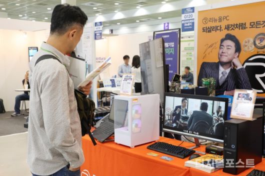 관람객이 중고 컴퓨터를 살펴보고 있다.