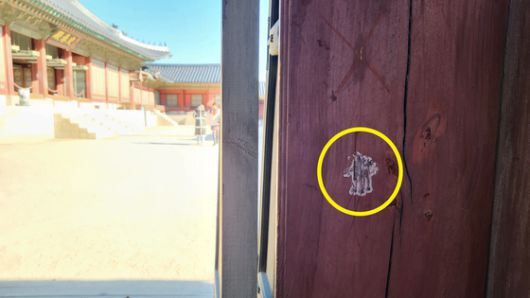 경복궁 교태전으로 향하는 문 옆쪽에는 오래 전 붙인 듯한 판박이 스티커가 남아있다. 〈사진=이지현 기자〉