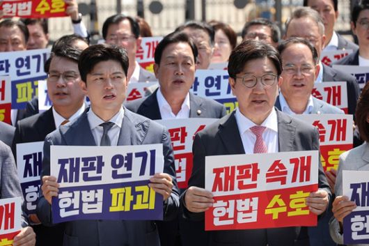 김용태 국민의힘 비상대책위원장과 권성동 원내대표가 오늘(11일) 이재명 대통령의 공직선거법 위반 사건의 파기환송심을 사실상 무기한 연기한 서울고등법원 앞에서 열린 현장 의원총회에서 구호를 외치고 있다. 〈사진=연합뉴스〉