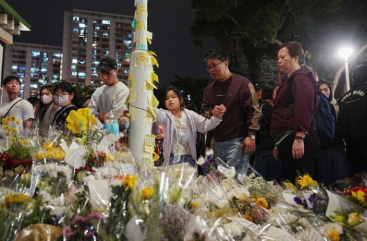 홍콩 시민이 '웡 푹 코트' 아파트 단지 화재 인근 공원에서 희생자를 추모한다 〈사진출처=로이터 연합뉴스〉
