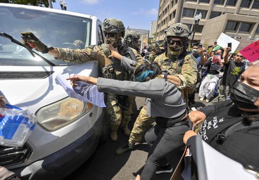 지난 9일 미국 LA 시내에서 경찰들이 시위대에 후추 스프레이를 뿌리고 있다. [사진 | 뉴시스]