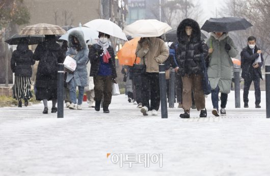 전국 대부분 지역에 눈이 내린 9일 오전 서울 영등포구 여의도역 일대에서 직장인들이 눈을 피해 출근길 발걸음을 재촉하고 있다. 조현호 기자 hyunho@