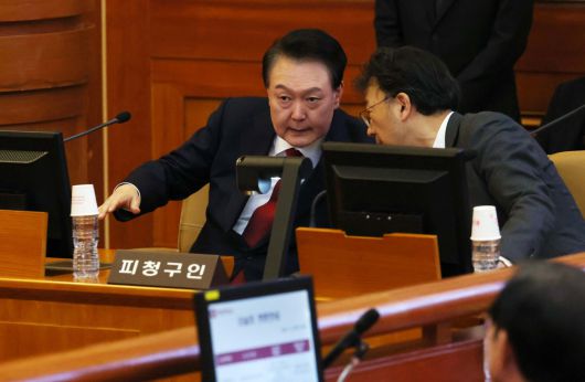 윤석열 대통령이 21일 서울 종로구 헌법재판소에서 열린 윤석열 대통령 탄핵심판 3차 변론기일에서 차기환 변호사와 대화하고 있다.