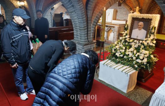 제266대 교황인 프란치스코 교황이 선종한 가운데 22일 서울 중구 서울대교구 주교좌 명동대성당 지하 성전에 마련된 빈소에서 조문객들이 추모를 하고 있다. 사진공동취재단