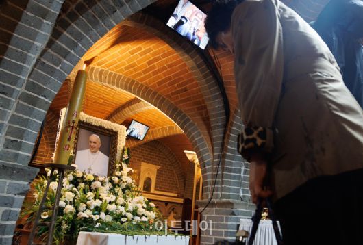 제266대 교황인 프란치스코 교황이 선종한 가운데 22일 서울 중구 서울대교구 주교좌 명동대성당 지하 성전에 마련된 빈소에서 조문객들이 추모를 하고 있다. 사진공동취재단