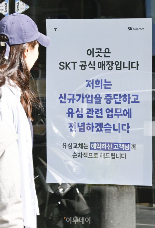 6일 서울 시내의 한 SK텔레콤 직영점에서 시민들이 신규 가입 업무 중단 안내문을 살펴보고 있다. SK텔레콤은 5일부터 유심(USIM) 정보 해킹 사고로 유심 교체를 원하는 기존 가입자부터 우선적으로 교체하기 위해 전국 T월드 매장과 온라인에서 신규 가입 업무를 중단했다. 조현호 기자 hyunho@