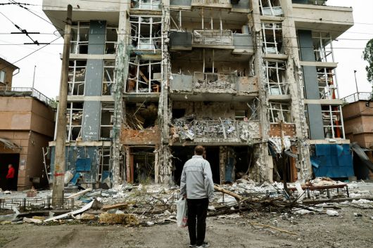 우크라이나 키이우에서 25일(현지시간) 시민이 무너진 아파트를 보고 있다. 키이우/로이터연합뉴스