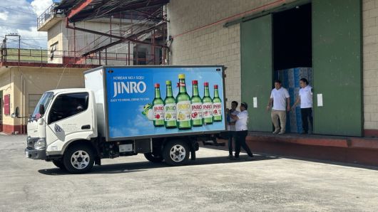 필리핀 유통업체 K&L의 창고에서 진로 제품이 차에 실리고 있다.