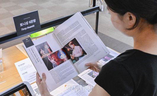 20일 서울 서초구 국립중앙도서관 연속간행물실에 마련된 한국 창작 뮤지컬 '어쩌면 해피엔딩'의 미국 토니상 최초 6관왕 기념 K-뮤지컬 특별코너에서 한 이용객이 토니상 수상 관련 기사를 살펴보고 있다. 국립중앙도서관이 한국 뮤지컬의 태동과 성장, 세계 무대에서의 가능성을 조명하기 위해 마련한 이번 코너는 작품에 관한 자료, 박찬휴 작가 과거 인터뷰, 토니상 시상식 영상 등을 전시한다. 조현호 기자 hyunho@