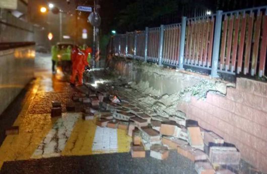 호우경보가 발효된 14일 오전 부산 수영구의 한 공원 담장 일부가 무너져 있다.