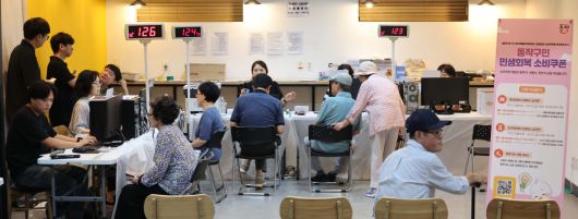 민생회복 소비쿠폰 신청이 시작된 21일 서울 동작구 대방동주민센터 작은도서관에서 시민들이 소비쿠폰 신청을 하고 있다.