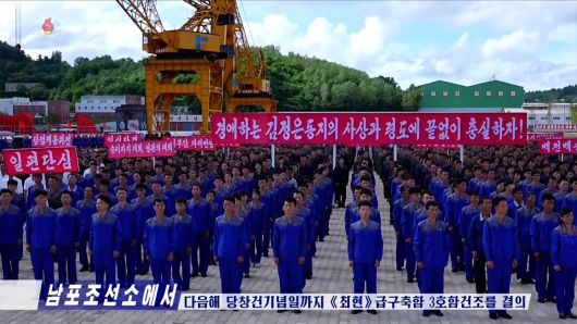 21일 북한 남포조선소 노동자들이 최현급 구축함 3호함 건조를 위한 궐기모임을 진행하고 있다.
