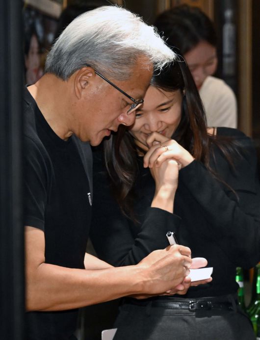 젠슨 황 엔비디아 최고경영자(CEO)가 30일 오후 서울 강남구 삼성역 인근 깐부치킨 매장에서 이재용 삼성그룹 회장, 정의선 현대차그룹 회장과 치킨 회동 중 시민들에게 사인을 해주고 있다. 신태현 기자 holjjak@