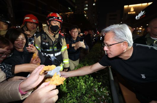 젠슨황 엔비디아 최고경영자가 30일 이재용 삼성전자 회장, 정의선 현대자동차그룹 회장과 서울 강남구 깐부치킨 매장에서 치킨 회동 중 밖으로 나와 시민들에게 치킨 등을 나눠주고 있다. 신태현 기자 holjjak@