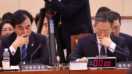 정성호(오른쪽) 법무부 장관과 안규백 국방부 장관이 7일 서울 여의도 국회에서 열린 법제사법위원회 전체회의에서 얼굴을 만지고 있다. 고이란 기자 photoeran@