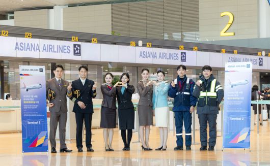 아시아나항공이 14일 인천공항 제 2 여객터미널에서 운항을 시작했다. 아시아나항공과 대한항공 양사 직원들이 터미널 이전 기념 촬영을 하고있다.