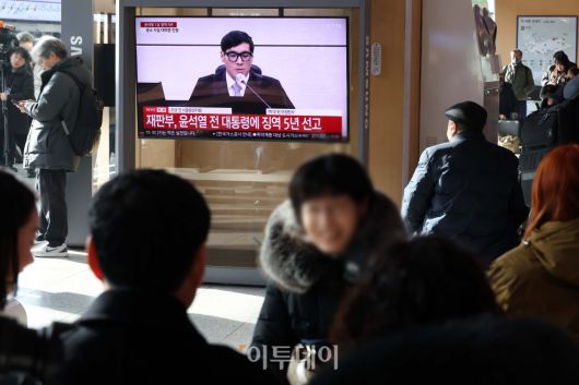 16일 서울역 대합실에서 시민들이 고위공직자범죄수사처(공수처)의 체포영장 집행 방해 등 혐의로 재판에 넘겨진 윤석열 전 대통령의 1심 선고 공판 생중계를 지켜보고 있다. 법원은 윤 전 대통령에게 징역 5년을 선고했다. 이번 선고는 내란 관련 사건 재판 중 처음으로 나오는 판결이다. 고이란 기자 photoeran@