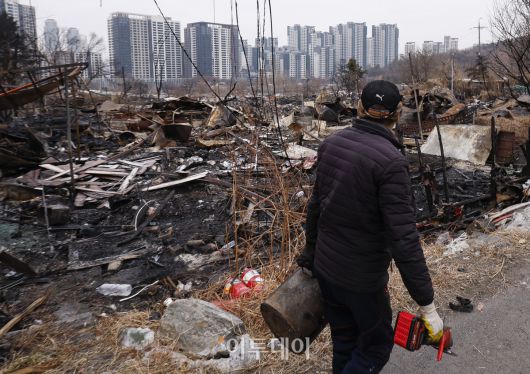 18일 서울 강남구 개포동 구룡마을 화재 현장에서 한 주민이 전소된 주택을 바라보고 있다. 16일 오전 5시쯤 구룡마을 4지구에서 발생한 화재로 소방당국은 대응 2단계를 발령해 6시간 30여 분만에 불을 진화했다. 이 과정에서 소방 343명과 경찰 560명 등 인력 1258명과 장비 106대가 투입됐다. 인명 피해는 없었으나 165세대 258명이 대피했고, 이 중 129세대 181명이 이재민이 됐다. 관계 당국은 19일 합동 감식에 나설 예정이다. 조현호 기자 hyunho@