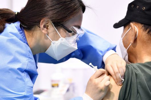 수원시에서 한 어르신이 예방접종을 받고 있다,